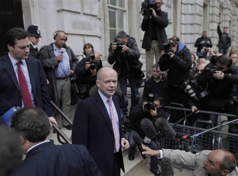 Conservative shadow Foreign Secretary William Hague, center, talks to members of the media as George Osborne, left, shadow finance minister, looks on as they arrive for their meeting with representatives of the Liberal Democrats on Sunday in London.